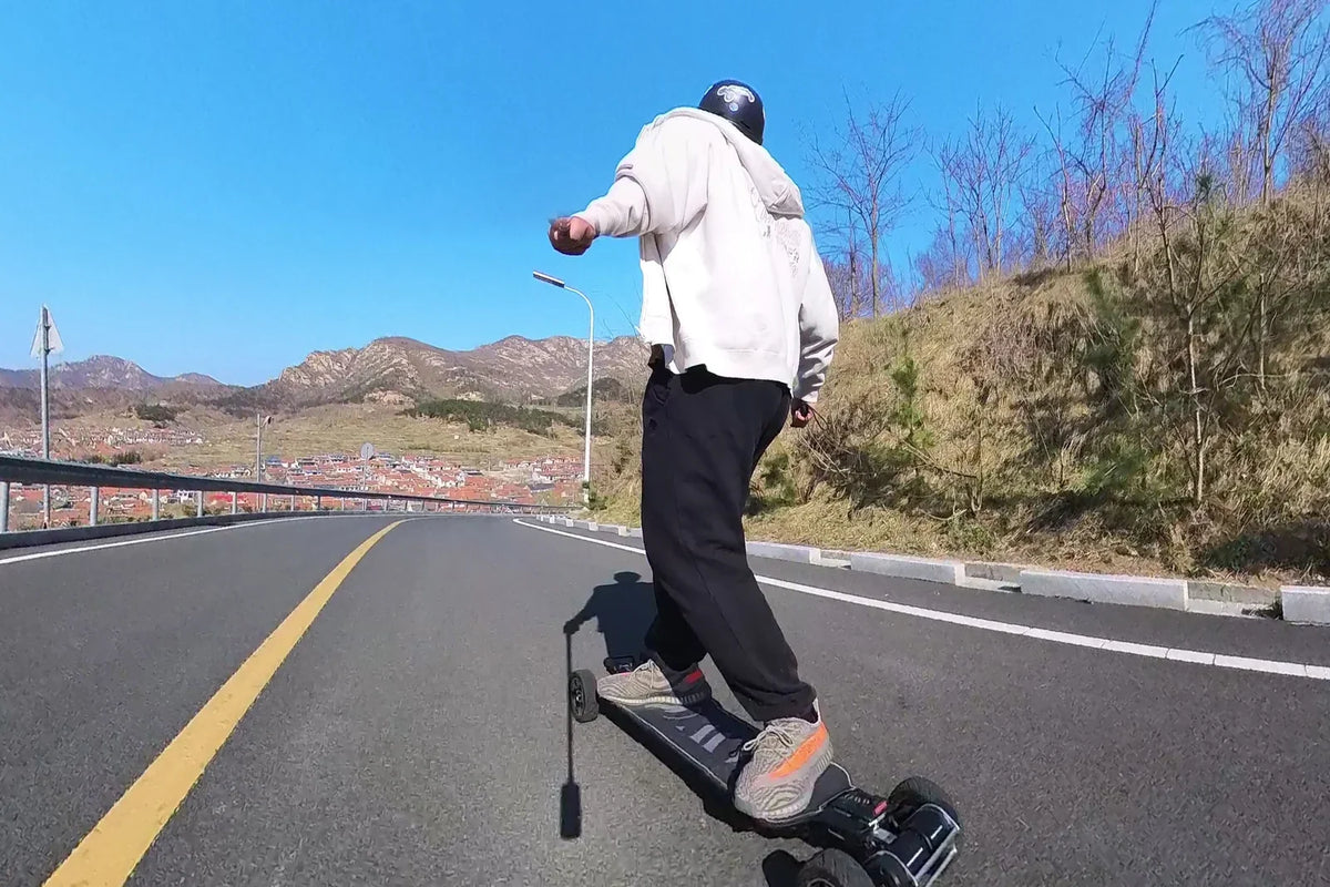 Helmeted rider practicing balance on an OMW Hussar with 125 mm wheels on dry pavement