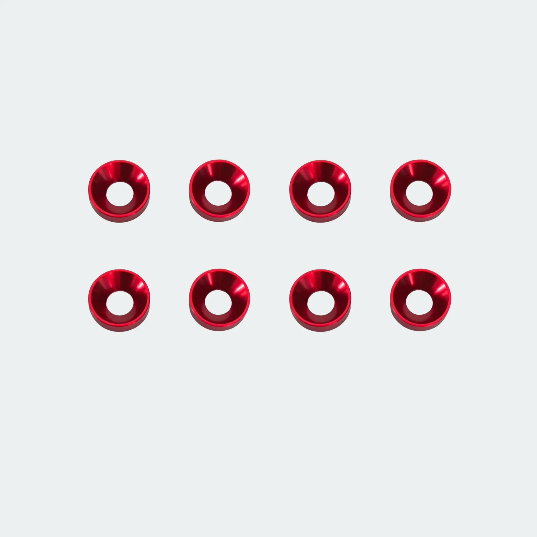 Red metal washers arranged in two rows on a white background